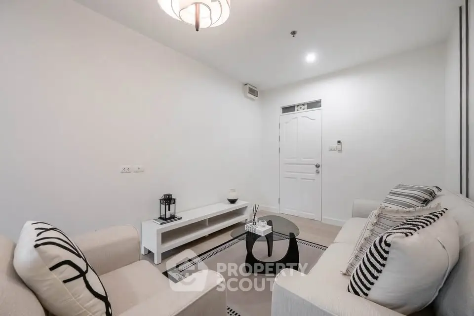 Modern living room with stylish decor and cozy seating in a bright, minimalist apartment.