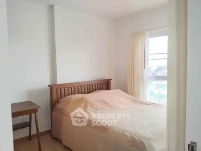 Cozy bedroom with wooden bed frame and city view window, perfect for relaxation.