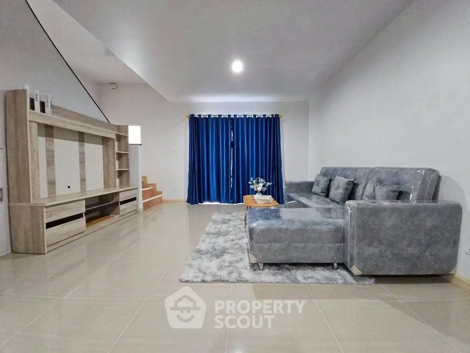 Spacious modern living room with stylish gray sectional sofa and elegant entertainment center.
