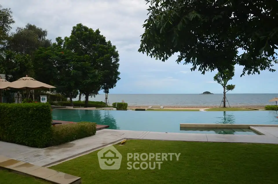 Luxurious beachfront pool with stunning ocean view and lush greenery.