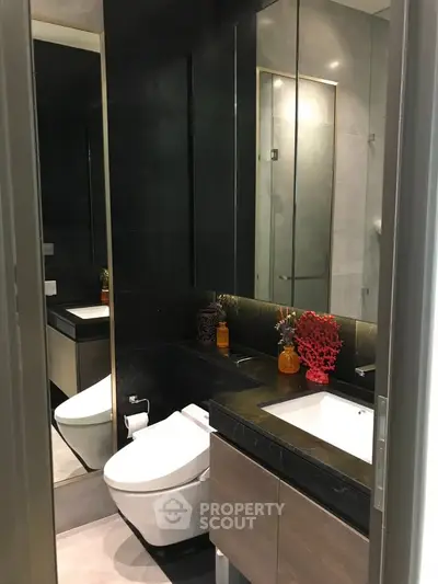 Modern bathroom with sleek design, featuring a glass shower and elegant fixtures.