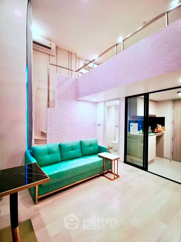 Modern duplex living room with green sofa and open kitchen layout