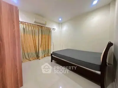 Spacious bedroom with modern design and ample natural light, featuring a comfortable bed and elegant curtains.