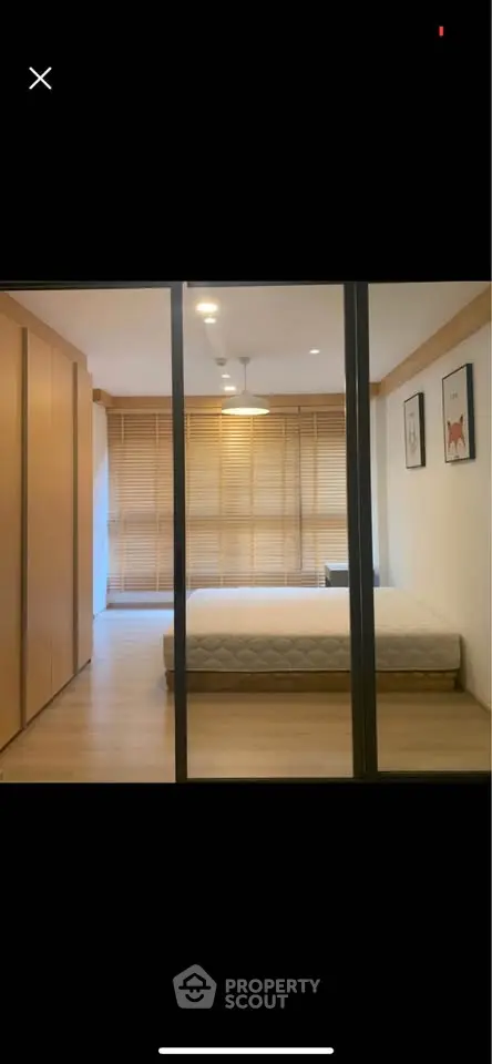 Modern minimalist bedroom with wooden flooring and large windows