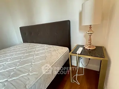 Cozy bedroom with modern bed and stylish lamp on wooden floor