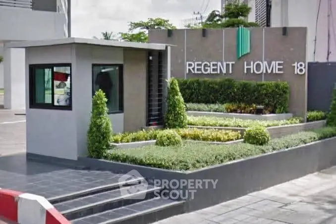 Modern entrance of Regent Home 18 with landscaped greenery and sleek design.