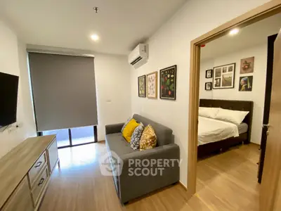 Modern apartment living room with cozy sofa and bedroom view