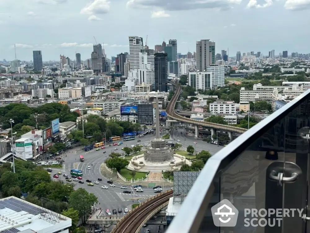 Stunning cityscape view from high-rise balcony overlooking urban skyline and bustling roundabout.