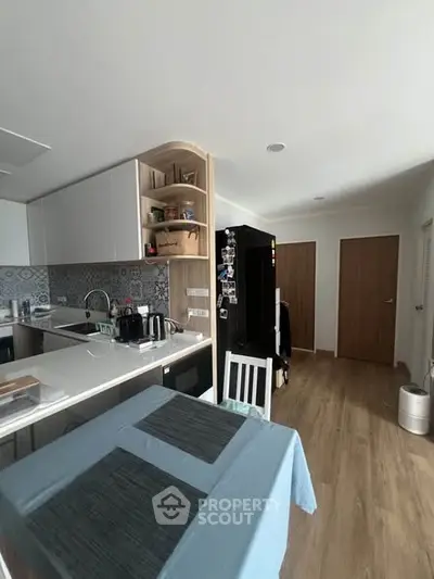 Modern kitchen with open layout and sleek appliances in a cozy apartment setting.