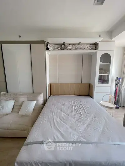 Modern bedroom with foldable bed and stylish sofa in compact space