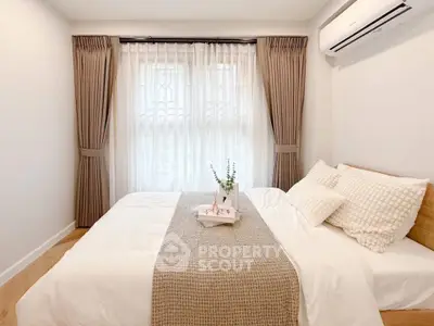Cozy bedroom with elegant curtains and air conditioning, perfect for relaxation.