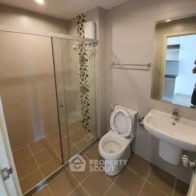 Modern bathroom with glass shower and sleek fixtures in contemporary apartment.