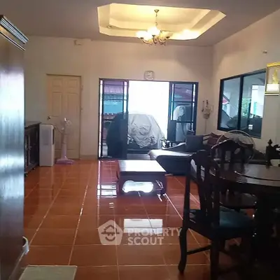 Spacious living room with elegant furniture and bright tiled flooring, perfect for family gatherings.