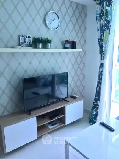 Modern living room with stylish decor, TV unit, and natural light from balcony.