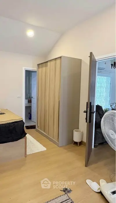 Spacious bedroom with modern wardrobe and wooden flooring