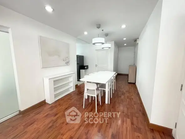 Spacious dining area with modern white furniture and wooden flooring