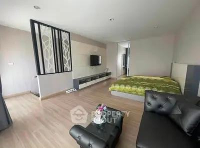 Spacious modern bedroom with stylish decor and open layout, featuring a cozy seating area and elegant flooring.