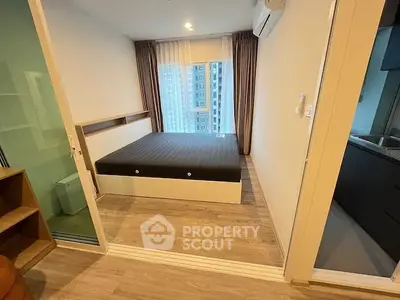 Modern bedroom with large window and city view, featuring sleek design and wooden flooring.