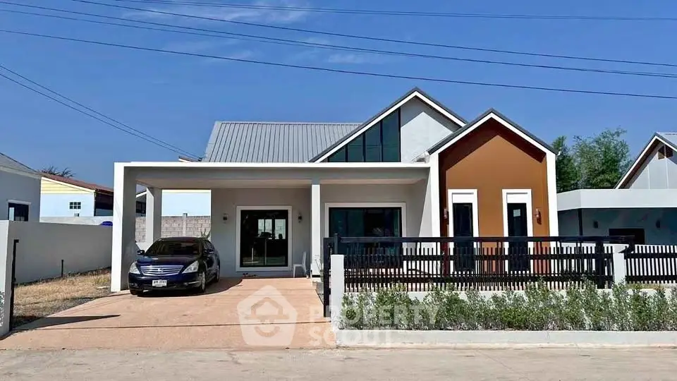 Modern single-story house with carport and stylish facade under clear blue sky.