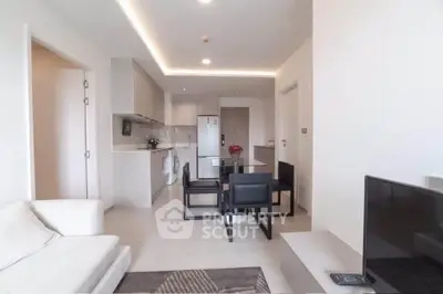 Modern open-plan living room with sleek kitchen and dining area, featuring contemporary furniture and neutral decor.