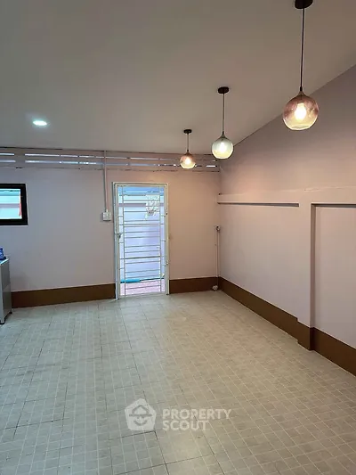 Spacious interior with modern lighting and tiled flooring, ideal for versatile use.