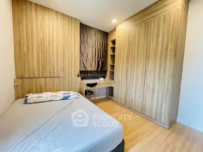 Modern bedroom with wooden wardrobe and study desk, perfect for a cozy living space.