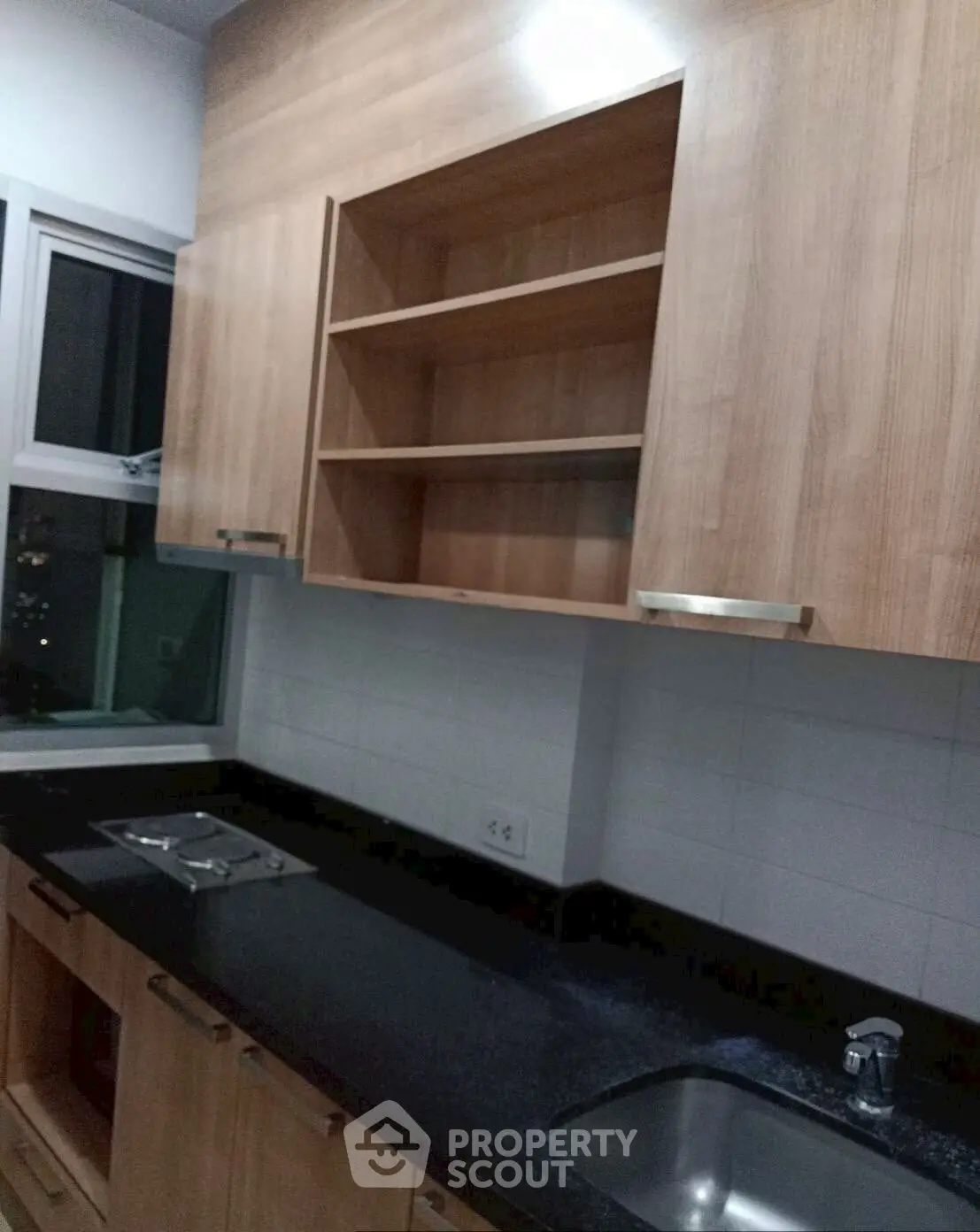 Modern kitchen with sleek black countertop and wooden cabinets