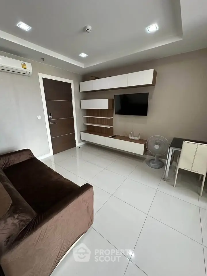 Modern living room with sleek furniture and wall-mounted TV in a stylish apartment.