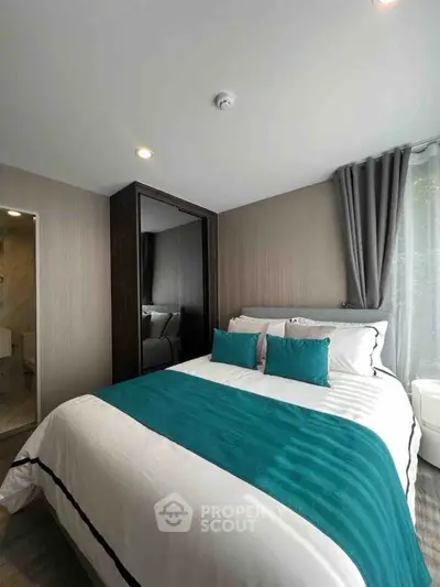 Modern bedroom with teal accents and large mirror wardrobe
