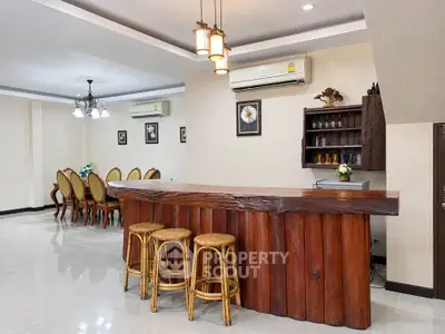Spacious dining area with rustic wooden bar and elegant seating, perfect for entertaining guests.