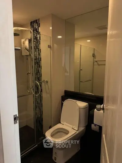 Modern bathroom with glass shower and sleek fixtures in a contemporary apartment.