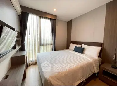 Cozy bedroom with modern decor and large window for natural light.