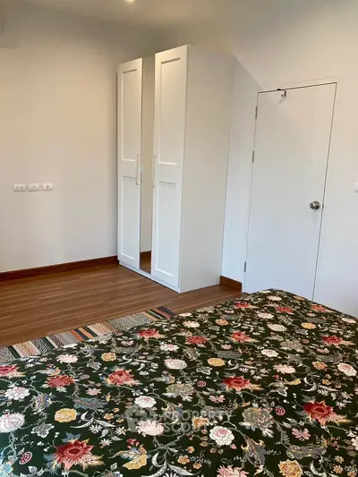 Cozy bedroom with floral bedding and sleek wardrobe
