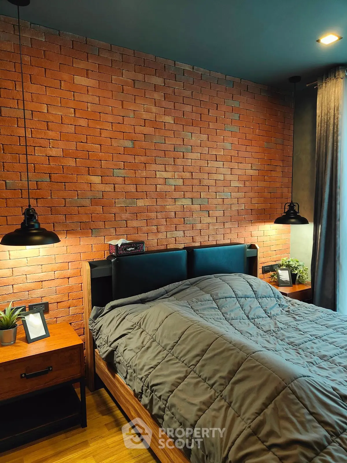 Cozy bedroom with exposed brick wall and modern lighting