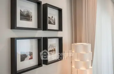 Elegant interior with framed art and modern lamp, showcasing stylish home decor.