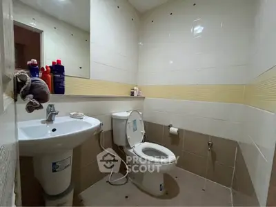 Compact bathroom with modern fixtures and neutral tile design, ideal for efficient space utilization.
