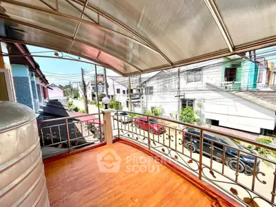 Spacious balcony with street view and modern railing in a vibrant neighborhood.