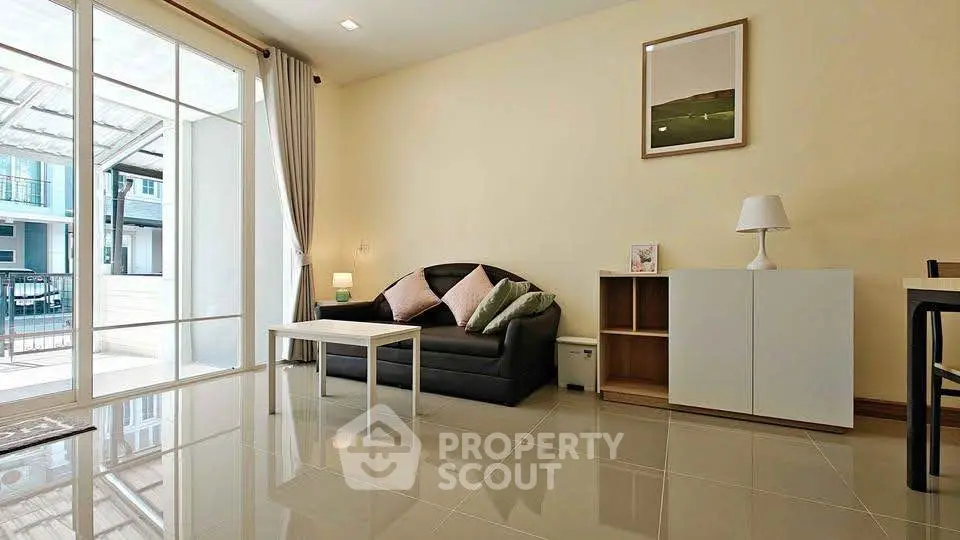 Modern living room with sleek tile flooring, cozy sofa, and large window for natural light.