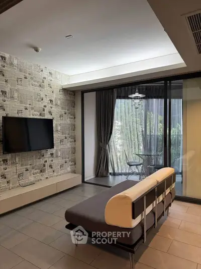 Modern living room with stylish decor and balcony view, featuring a sleek sofa and wall-mounted TV.
