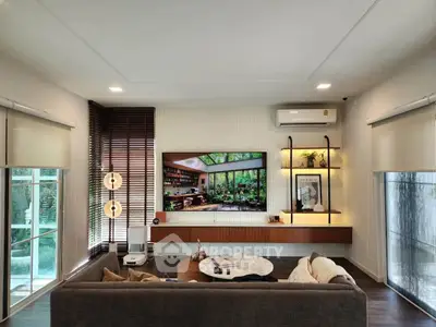 Modern living room with large windows, stylish decor, and cozy seating area.
