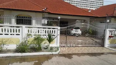 Charming suburban home with red-tiled roof and secure gated entrance, perfect for family living.