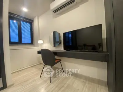 Modern minimalist living room with sleek furnishings, herringbone floor, and ample natural light, perfect for urban living.