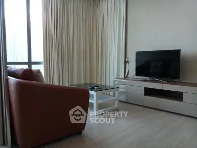 Modern living room with sleek furniture and large window for natural light.