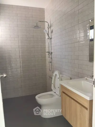 Modern bathroom with sleek tiles and contemporary fixtures in a stylish real estate property.