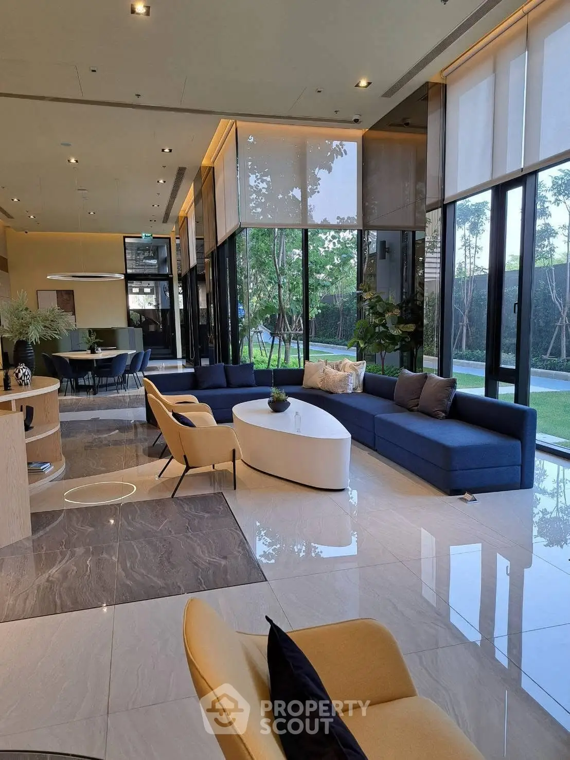 Luxurious modern living room with large windows and garden view, featuring elegant furniture and stylish decor.