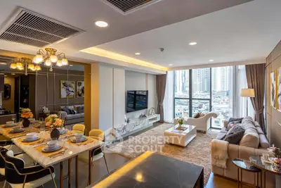 Luxurious open-plan living and dining area with city view, elegant decor, and modern furnishings.