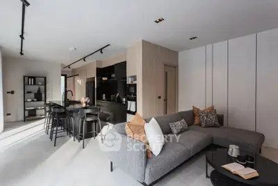 Modern open-plan living room and kitchen with sleek design and cozy seating area.