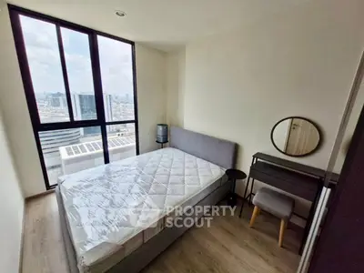 Modern bedroom with city view, featuring a cozy bed and stylish furniture in a high-rise apartment.