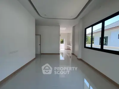 Spacious modern living room with large windows and glossy tiled floors