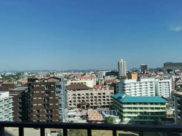 Stunning cityscape view from high-rise balcony showcasing urban skyline and clear blue sky.
